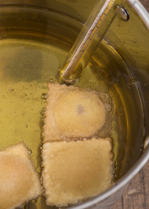 The ravioli frying in the hot oil.