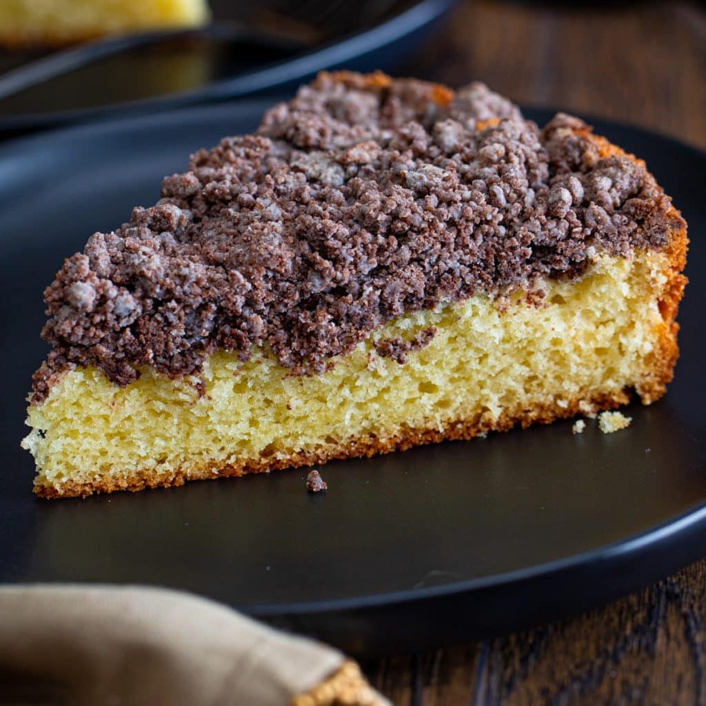 A slice of cake on a black plate.