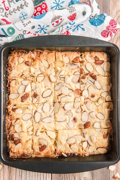 Almond bars baked and cut in a black pan.