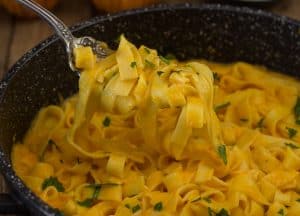 a forkful of creamy pumpkin pasta sauce fettucine