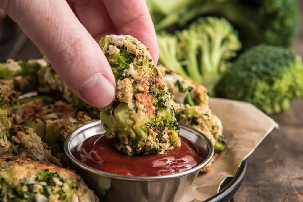 Dipping a broccoli tot in ketchup.