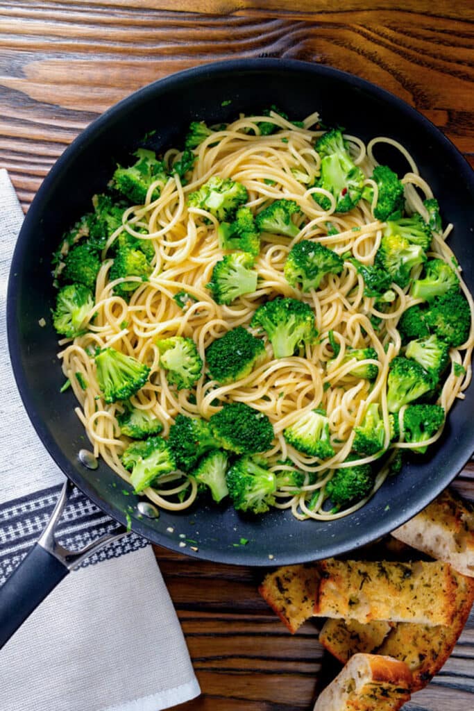 Pasta with broccoli in a black frying pan.