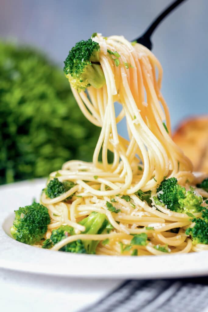 Pasta on a fork and on a white plate.