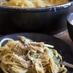 artichoke pasta on a black plate