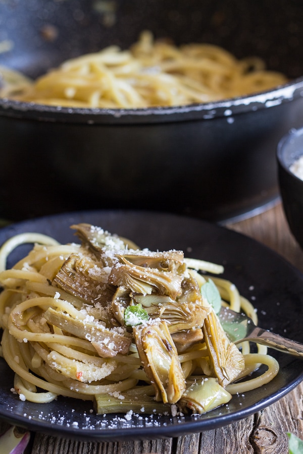 artichoke pasta on a black plate