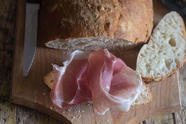 Ciabatta bread with prosciutto on top of a slice