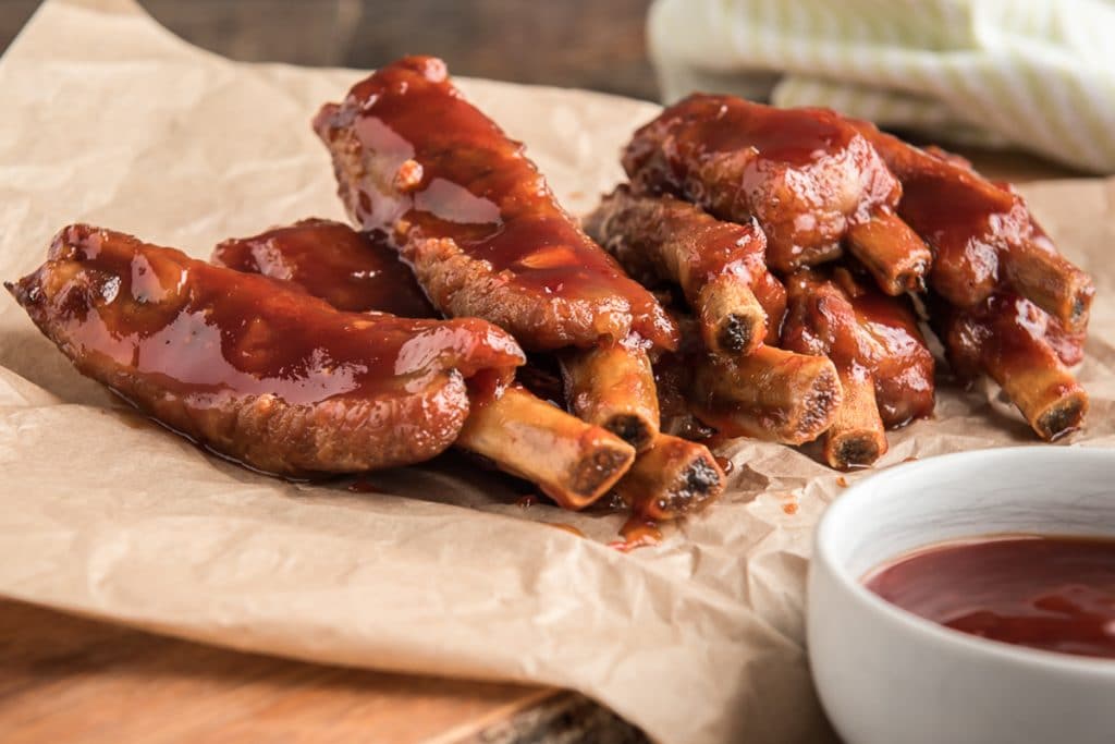 BBq oven baked ribs on brown paper.