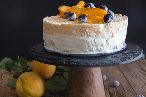 apricot cake on a black cake stand