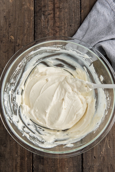 Adding the cream cheese to the whipped cream.