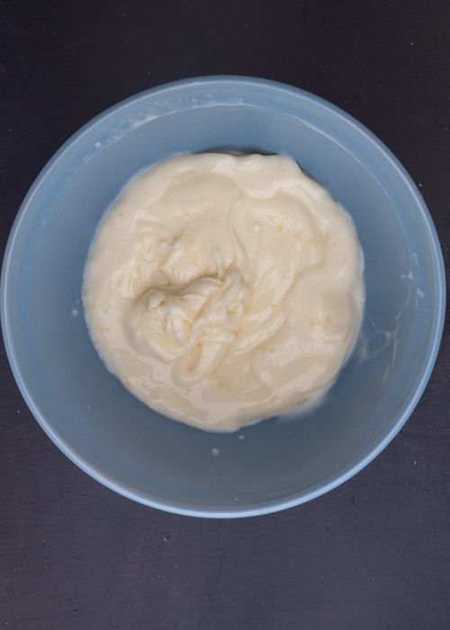 Sweetened condensed milk mixture in a blue bowl.