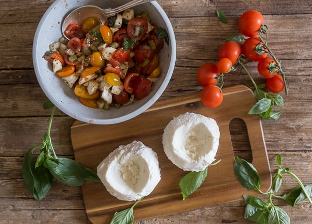 ingredients for caprese mozzarella chopped tomatoes and hollowed out mozzarella