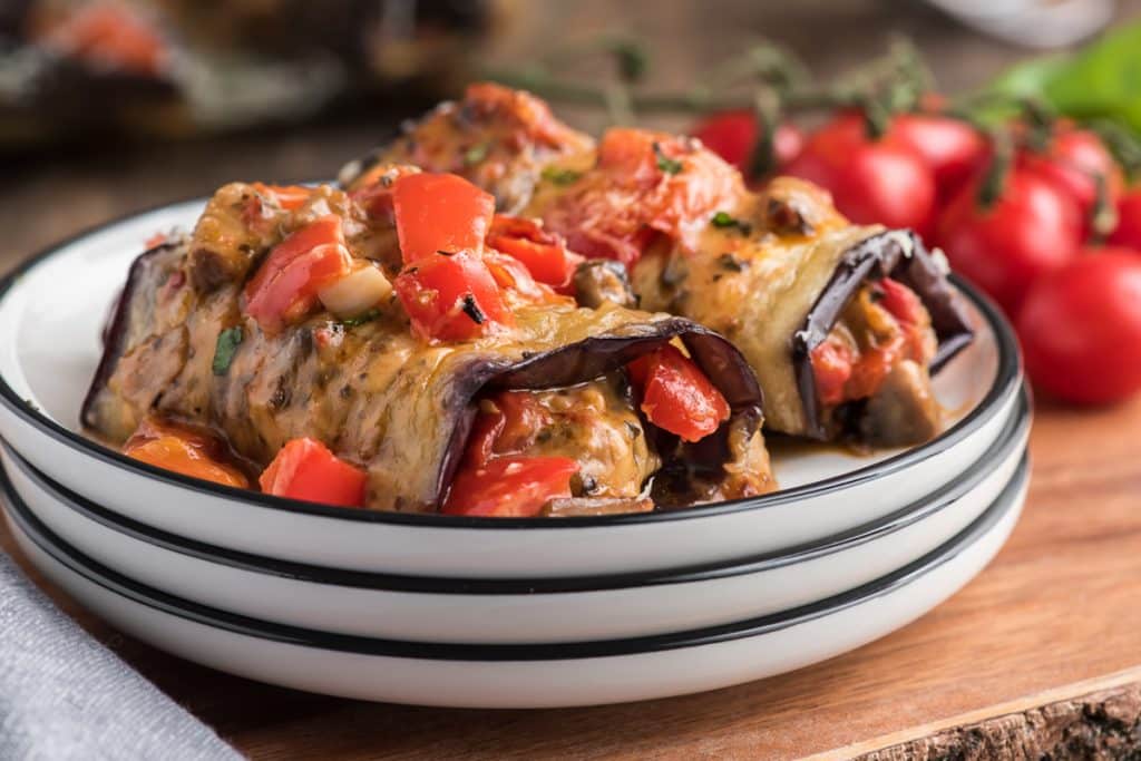 2 eggplant rolls on a white plate.