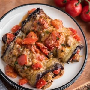 2 eggplant rolls on a white plate.