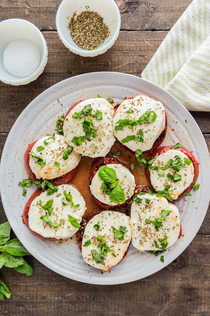 Grilled tomatoes on a plate with the spices.