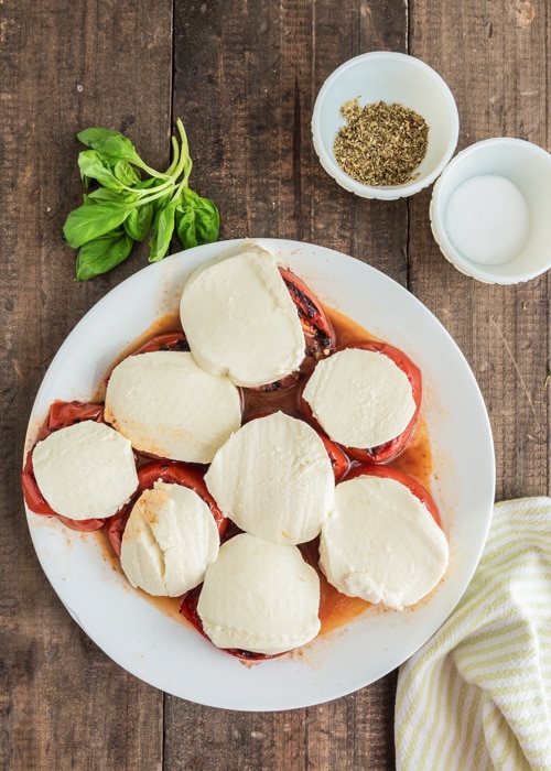 Tomatoes with the mozzarella on a white plate.