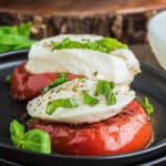 Grilled tomatoes on a white plate.