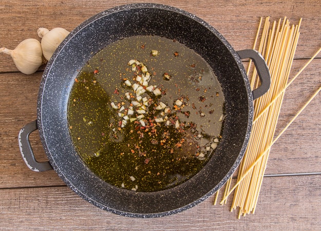 spaghetti aglio, olio e peperoncino in a pan with olive oil