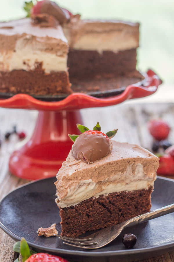 double chocolate mousse cake on a cake stand with a slice on a plate