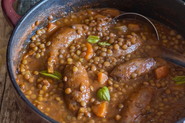 lentils sausage stew in a red pot