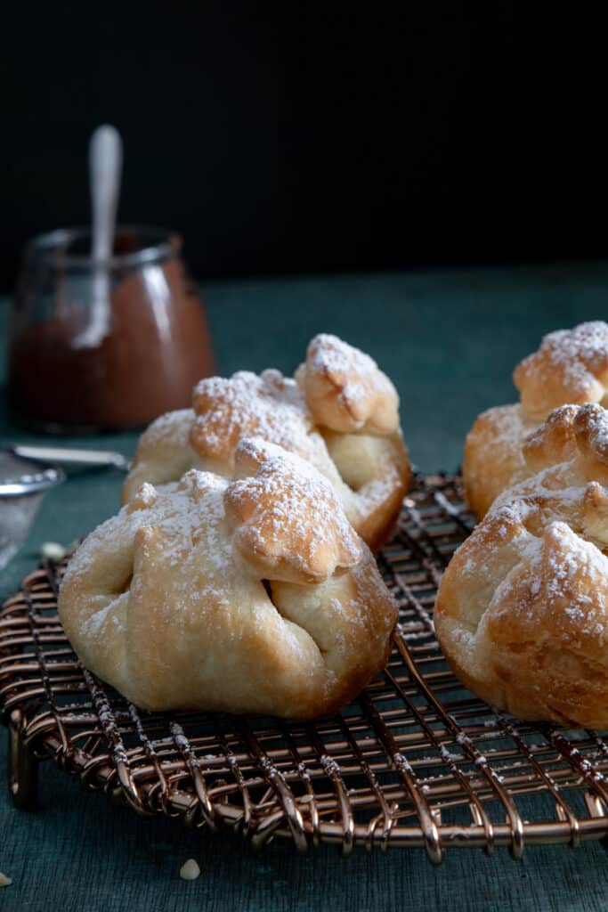 Puff pastry balls on a wire rack.