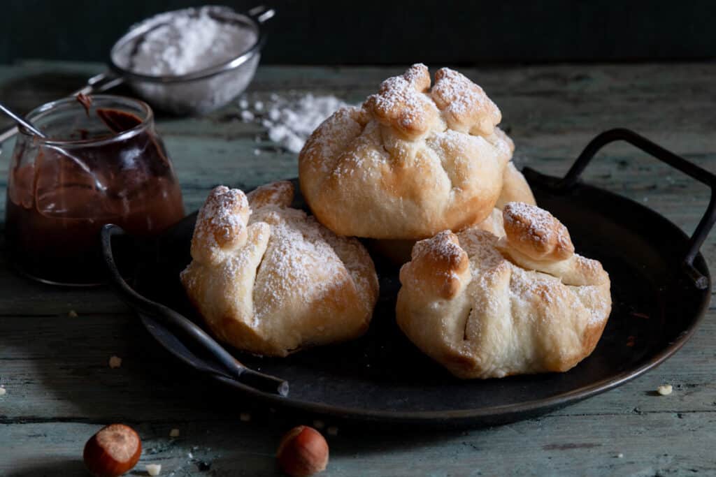 Puff pastry nutella balls on a black tray.