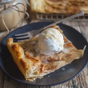 slice of cinnamon apple tart on a black plate