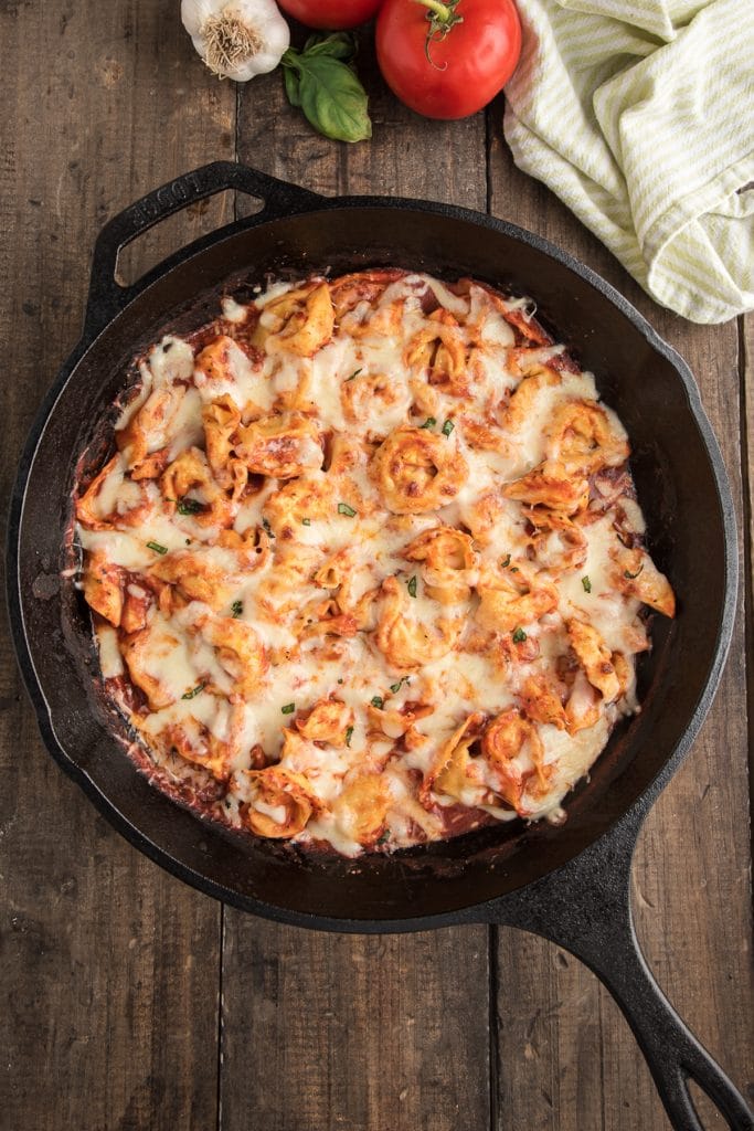 Baked tortellini in a black pan.