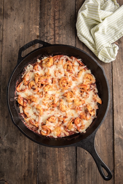 The baked tortellini in a black pan.