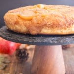 upside down apple cake on a black stand