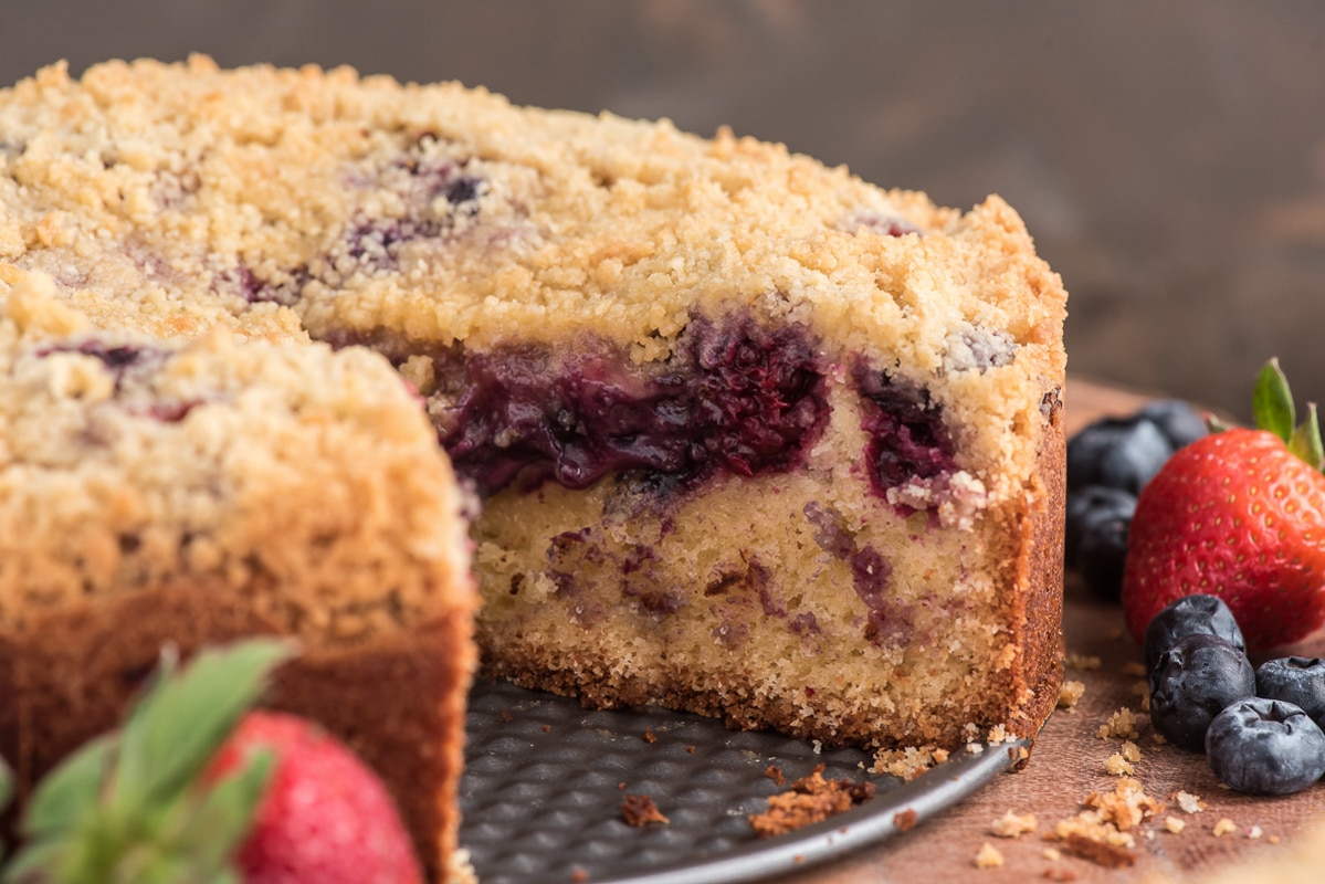 The cake on a wire rack with a slice cut.