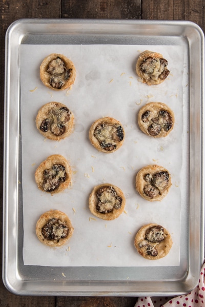 Mushroom puff pastry tarts baked on a cookie sheet.