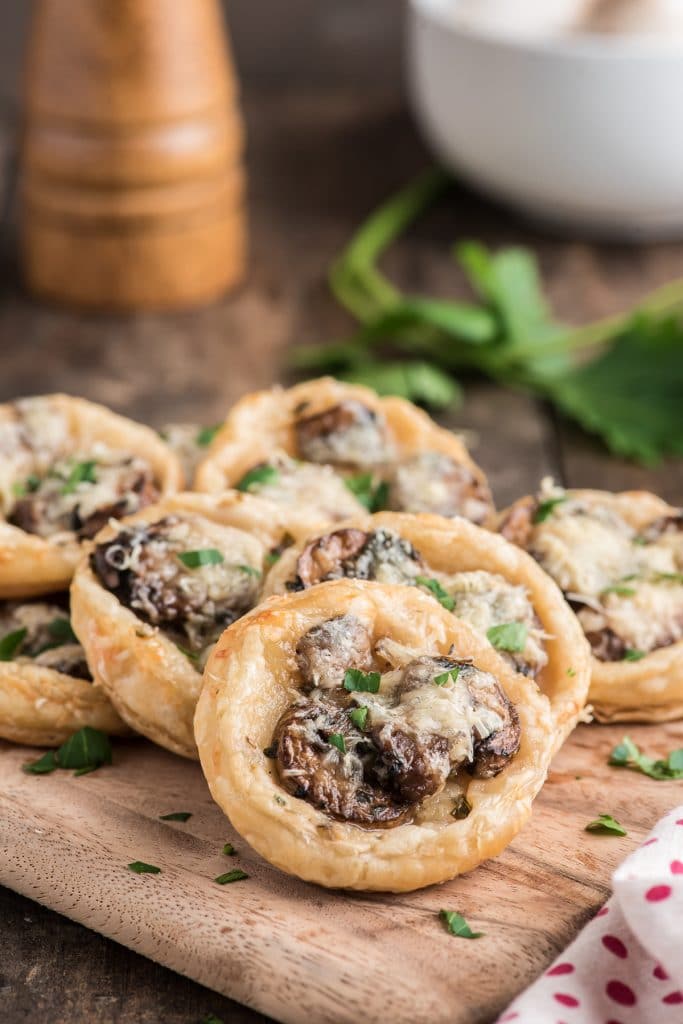 Mushroom puff pastry tarts on a wooden board.