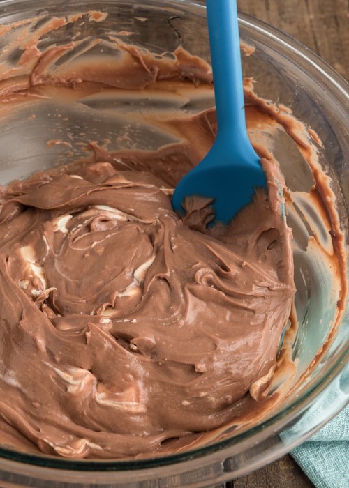 Adding the mascarpone to the pastry cream in a glass bowl.