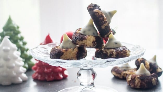 four cookies on a glass cake stand with 3 in front