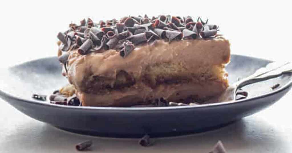 A slice of cake on a black plate.