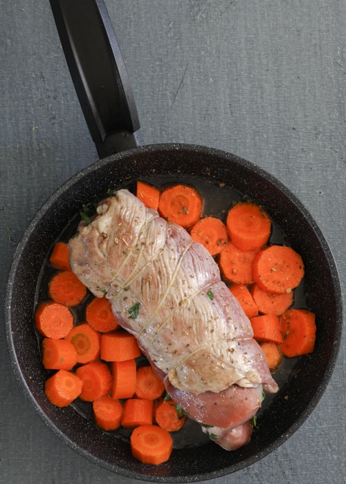 Adding the carrots and the flank steak to the pan.