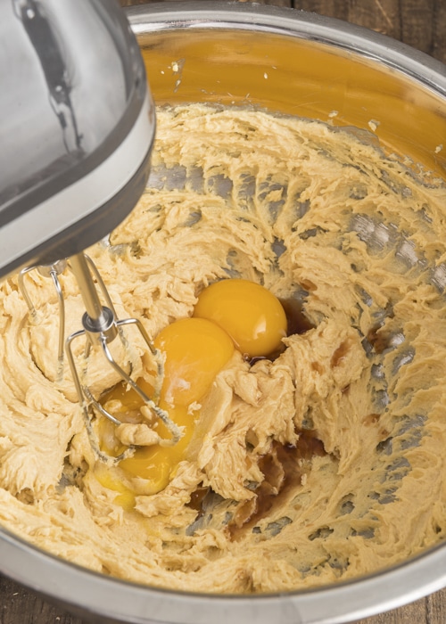 Beating the eggs into the cookie batter.