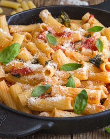 basil tomato sauce with rigatoni pasta in a black pan