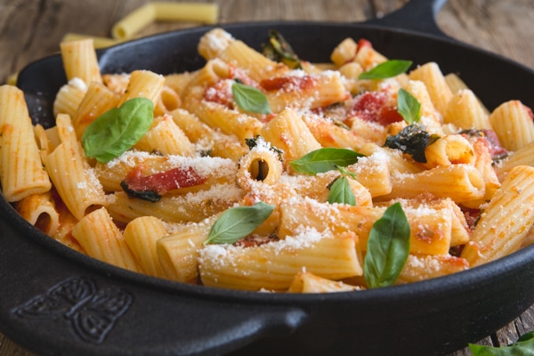 up close basil tomato sauce in a pan with rigatoni