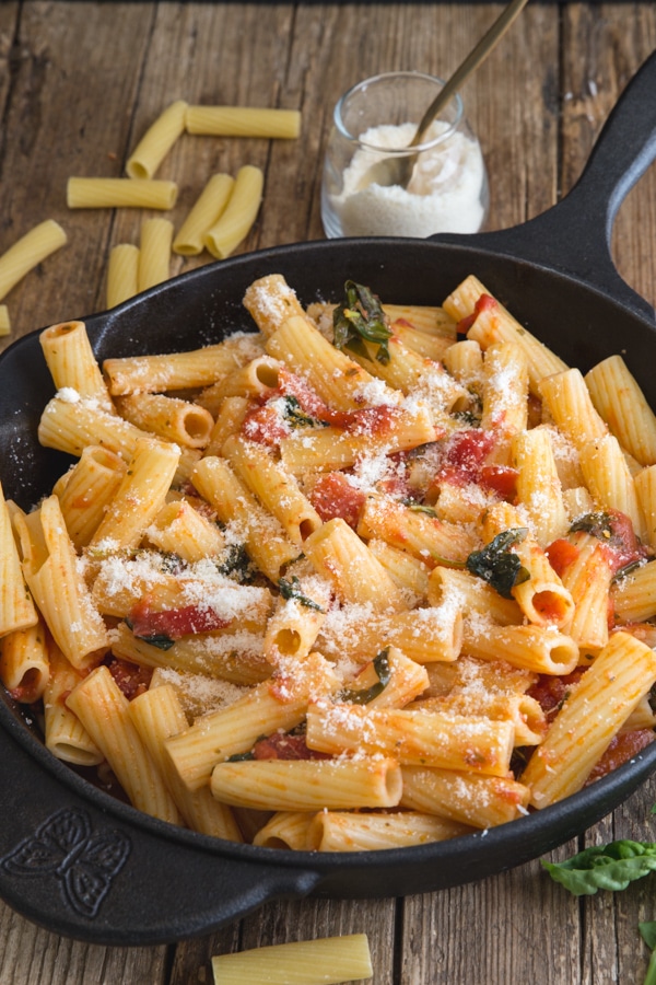 basil pasta sauce in a black pan with parmesan cheese