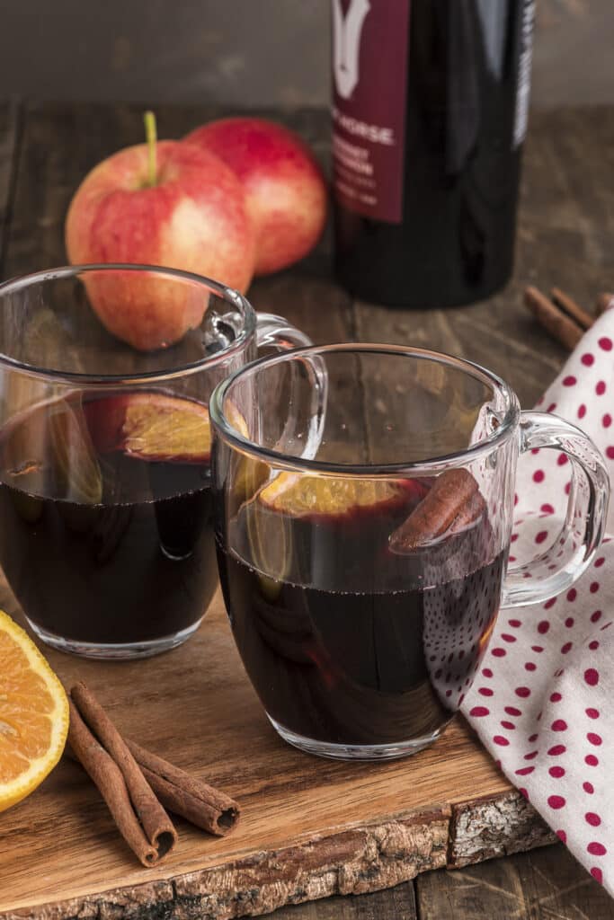 Two glasses of mulled wine on a wooden board.