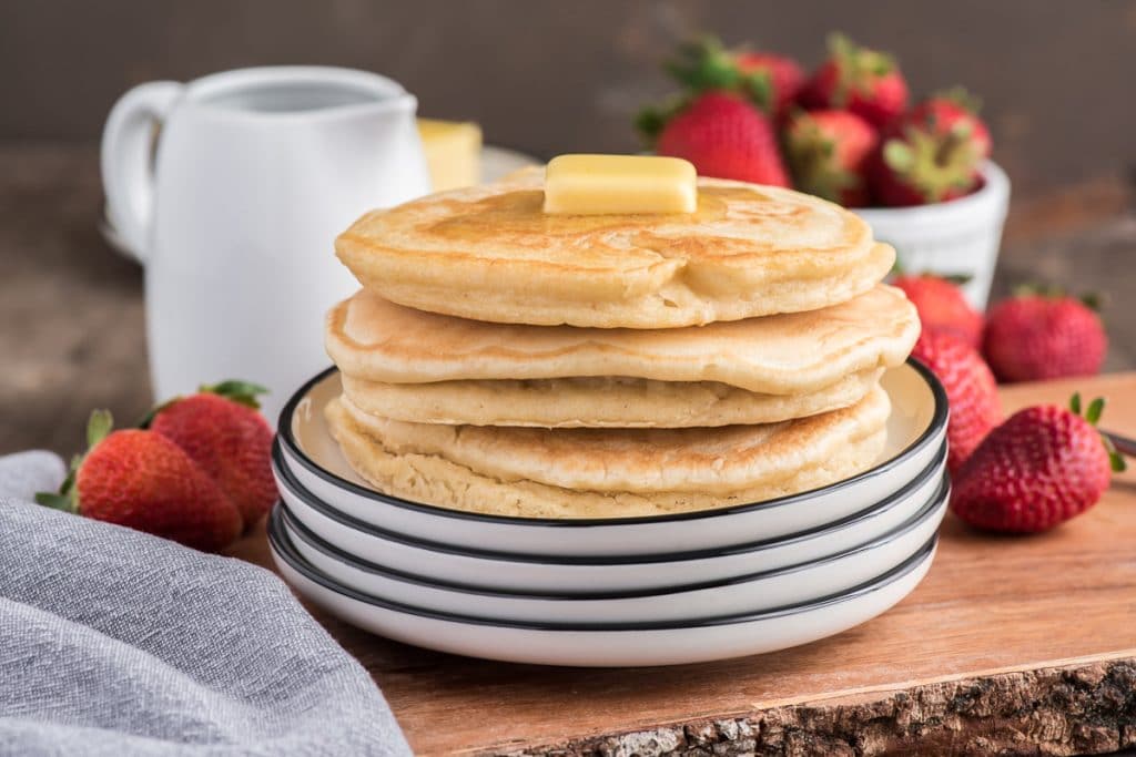Pancakes stacked on a white plate.