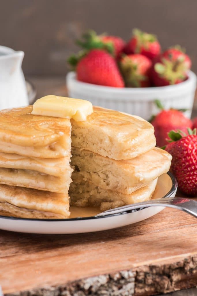 Pancakes stacked with a piece cut.