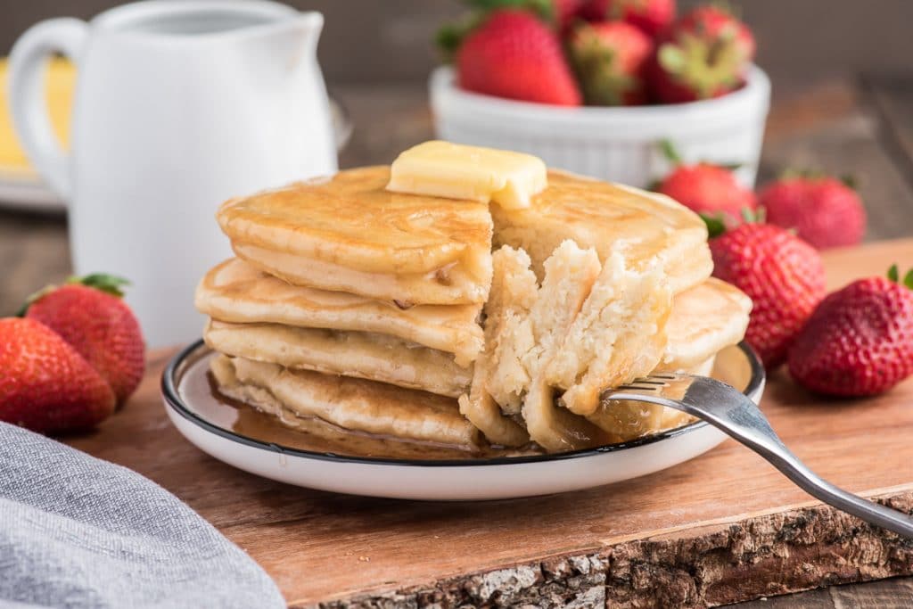 5 pancakes stacked with a cut piece on a fork.