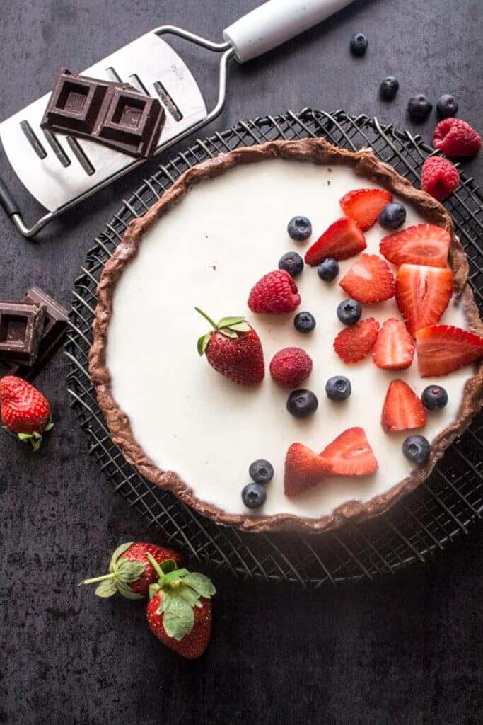 Tart with berries on a black board.