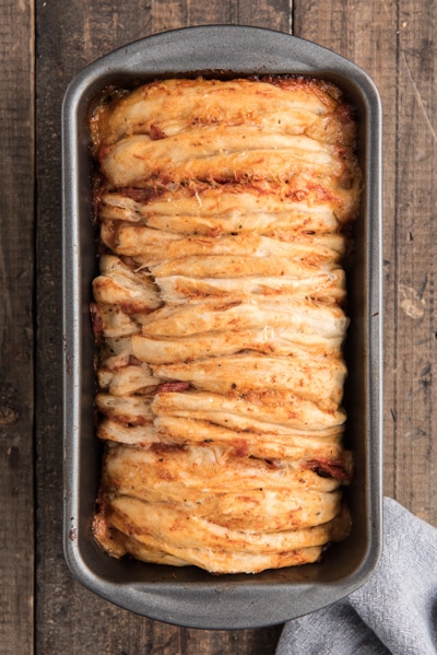 The baked pull apart bread in the loaf pan.