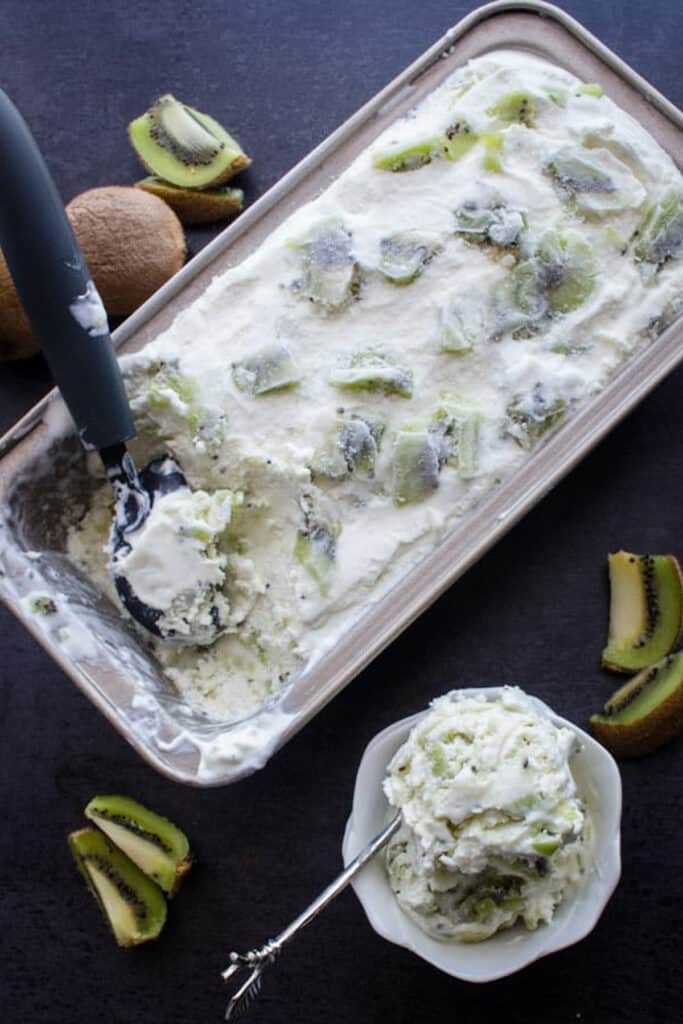 Kiwi ice cream in a loaf pan and some in a white bowl.
