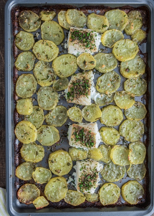 The baked fish and chips on the baking sheet.