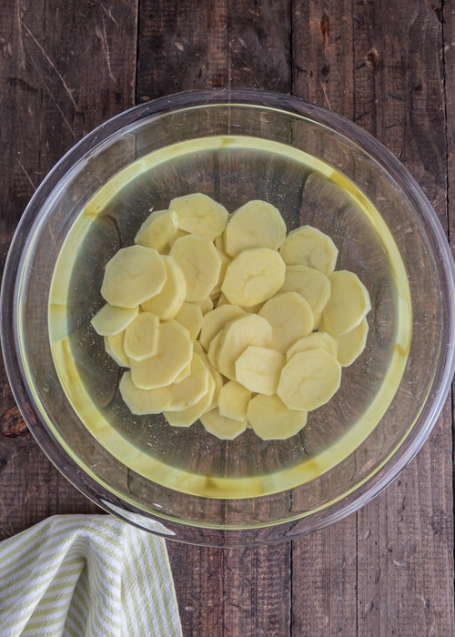 The potato slices in water in a bowl.