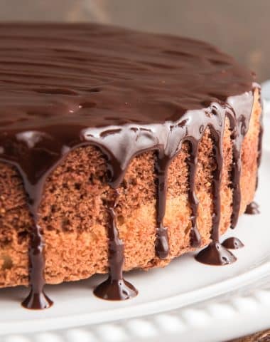 Chocolate glazed cake on a white plate.